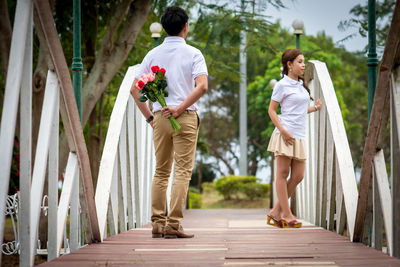 Rear view of man and woman walking on plants