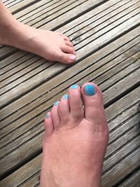 Low section of woman feet on wooden floor