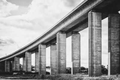 Low angle view of bridge against cloudy sky