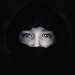 Portrait of beautiful woman against black background
