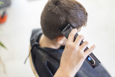 Cropped hand of barber cutting hairs