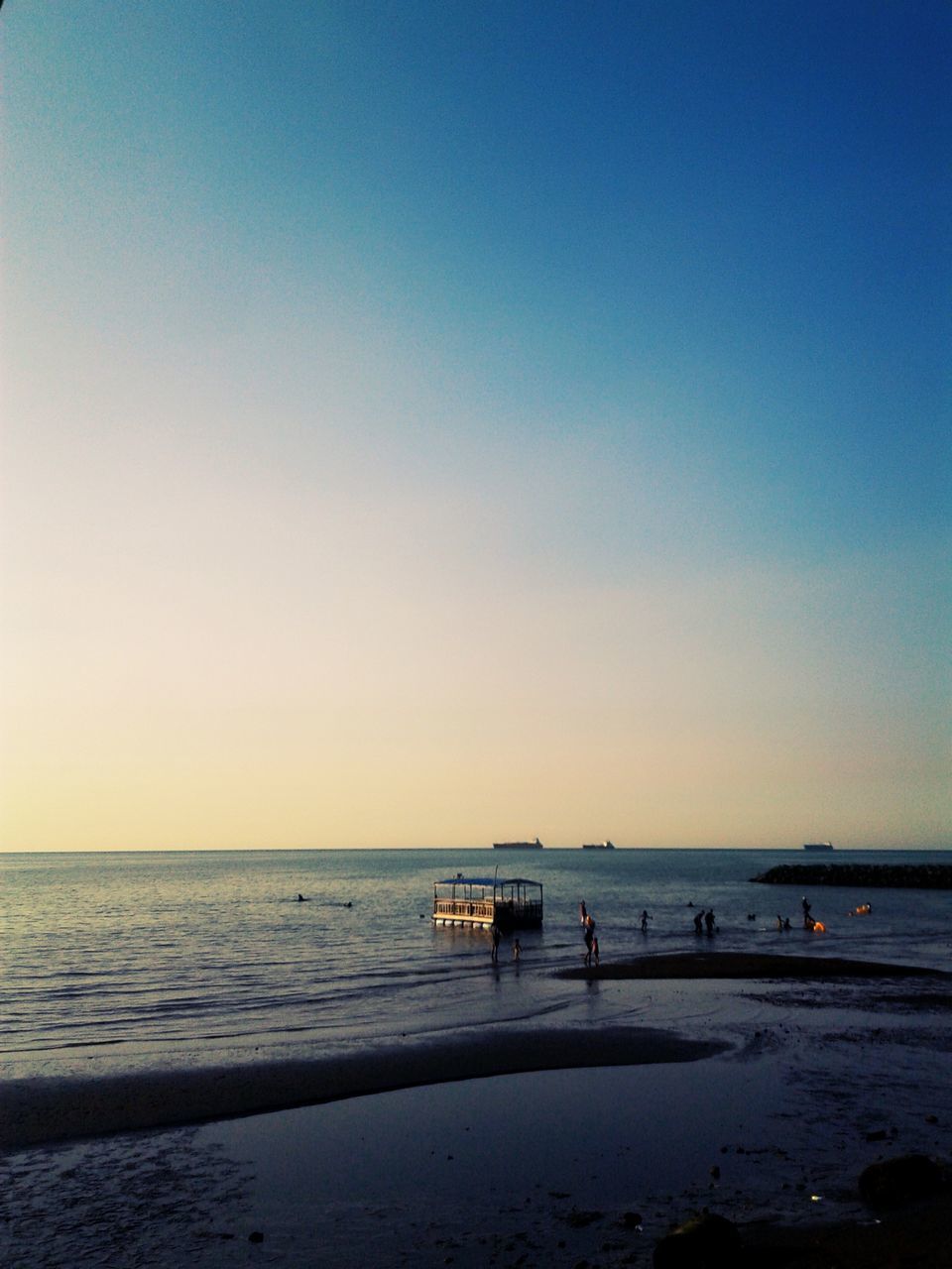 sea, water, horizon over water, beach, copy space, clear sky, tranquil scene, scenics, tranquility, beauty in nature, shore, sunset, sand, nature, idyllic, incidental people, blue, vacations, orange color, silhouette