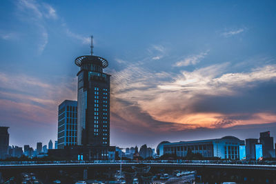 Modern buildings in city against sky during sunset