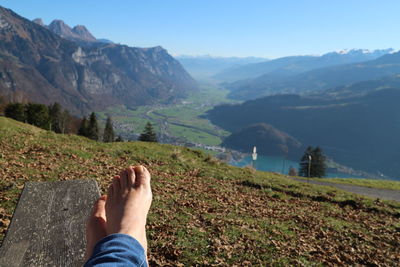 Low section of man on mountain against sky