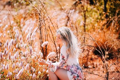 Portrait of young woman sitting on field