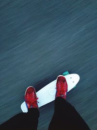 Low section of man skateboarding on road