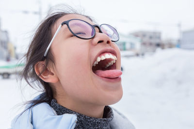 Close-up portrait of a smiling young woman in snow