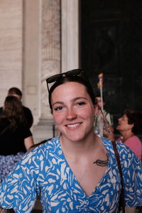 Low angle view of young woman with arms crossed