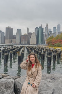 Young woman standing against river