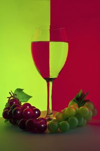 Close-up of fruits in glass against red background