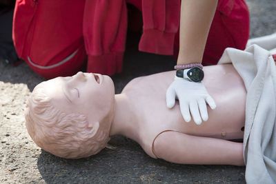 Midsection of paramedic performing cpr on dummy