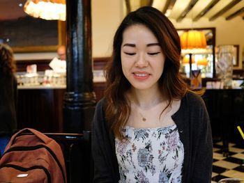 Portrait of beautiful young woman in restaurant