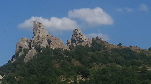 Low angle view of mountains against blue sky