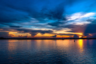 Scenic view of sea against dramatic sky during sunset