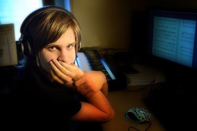 Portrait of teenage boy with headphones sitting at table
