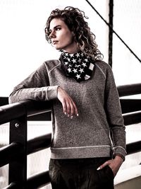 Portrait of beautiful young woman standing against railing