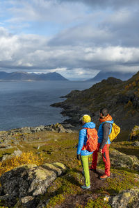 Couple looking at lake view from mountain on sunny day