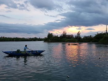 Boats in sea at sunset