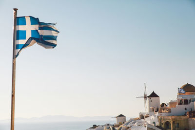 Greece flag waving at santorini against clear sky