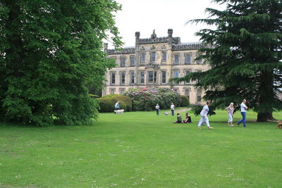 People in front of building against trees