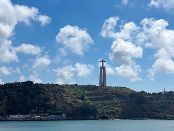 Lighthouse by sea against sky