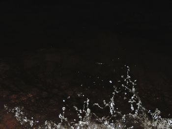 High angle view of water splashing against sky at night