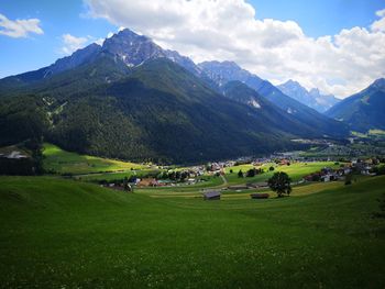 Scenic view of field and mountains against sky