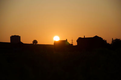 Silhouette buildings against sky during sunset