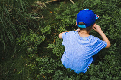 High angle view of boy collecting blueberries