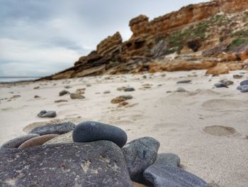 Close-up of rocks on beach against sky
