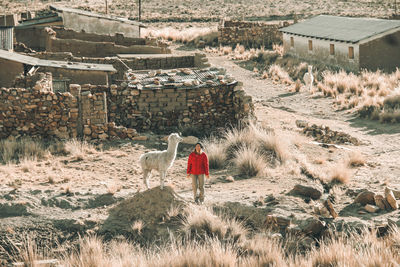 Rear view of woman walking on field