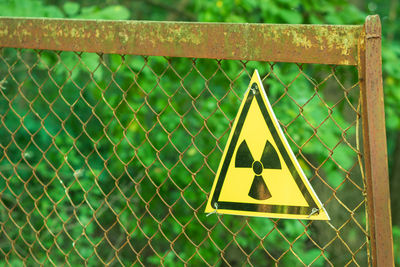 Close-up of warning sign on metal fence