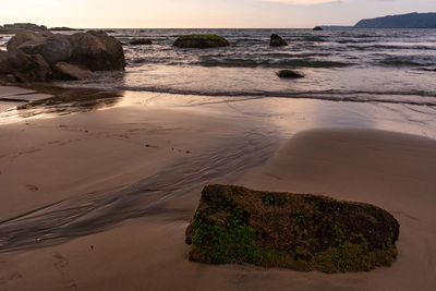 Scenic view of rocks on beach against sky