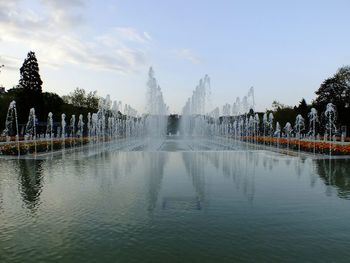 Fountain in lake against sky