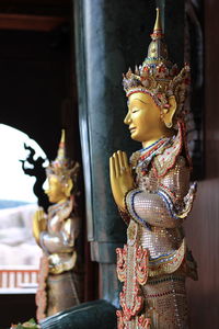 Close-up of buddha statue against building