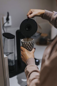 Woman's hands pouring coffee in mug