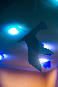 Low angle view of illuminated lighting equipment hanging on ceiling