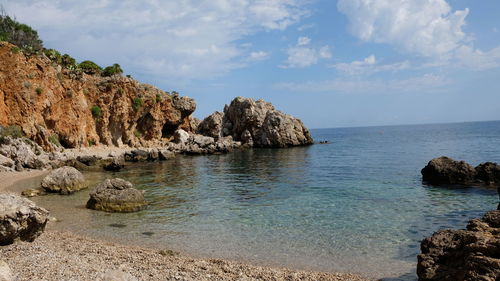 Scenic view of rocks in sea against sky