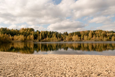 Scenic view of lake by trees against sky