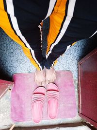 Low section of woman standing on pink umbrella