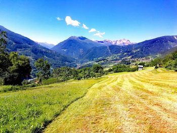 Scenic view of landscape and mountains against blue sky