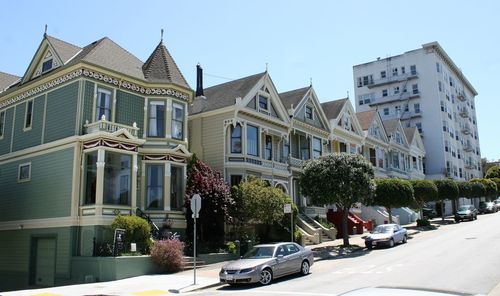 Cars on street by buildings against sky