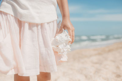 Midsection of woman standing on beach