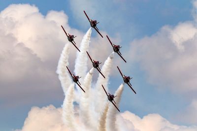 Low angle view of fighter planes flying against sky