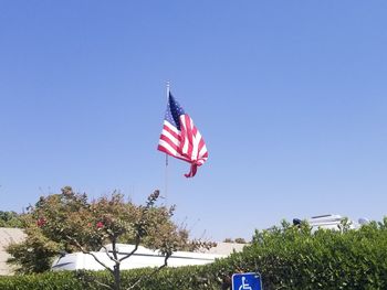 Low angle view of flag against clear blue sky