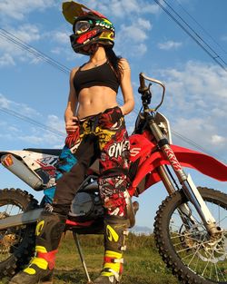 Low angle view of woman riding motorcycle against sky