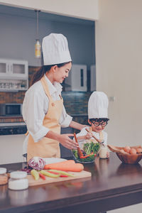 Woman standing by food in kitchen