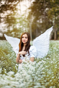 Young woman smiling while standing against plants