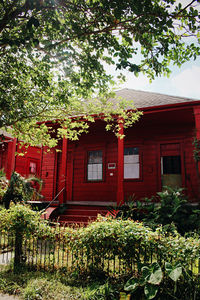 Red house and trees by building