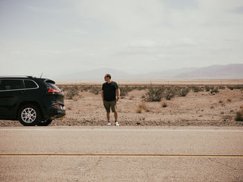 Full length of man standing on road against sky